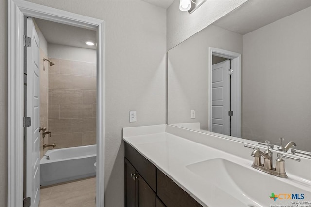 full bathroom with tiled shower / bath, vanity, and toilet