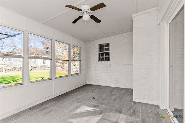 unfurnished sunroom featuring ceiling fan