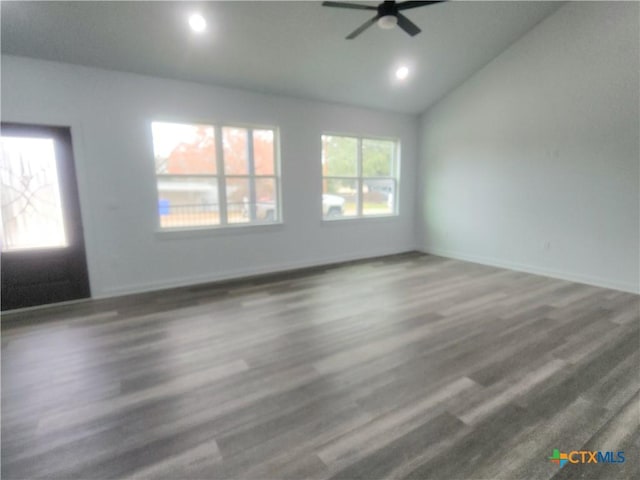 empty room featuring ceiling fan, dark hardwood / wood-style flooring, and vaulted ceiling