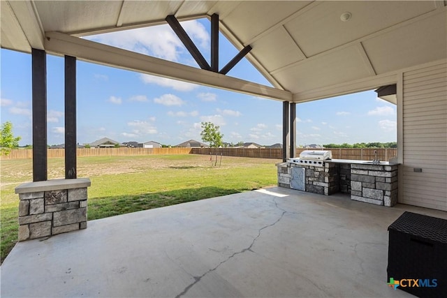 view of patio / terrace with a fenced backyard, a grill, and exterior kitchen