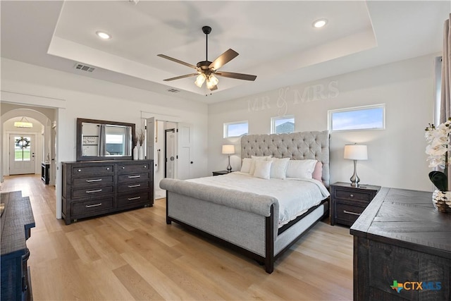 bedroom with visible vents, a tray ceiling, recessed lighting, and light wood-style floors