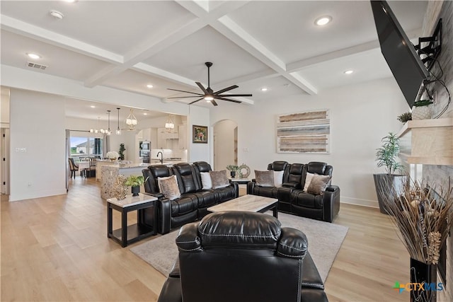 living room with light wood finished floors, arched walkways, visible vents, beamed ceiling, and ceiling fan