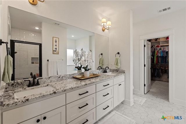 full bath featuring double vanity, a shower stall, visible vents, and a sink