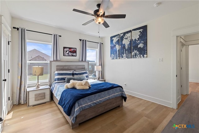 bedroom featuring light wood-type flooring, baseboards, and ceiling fan