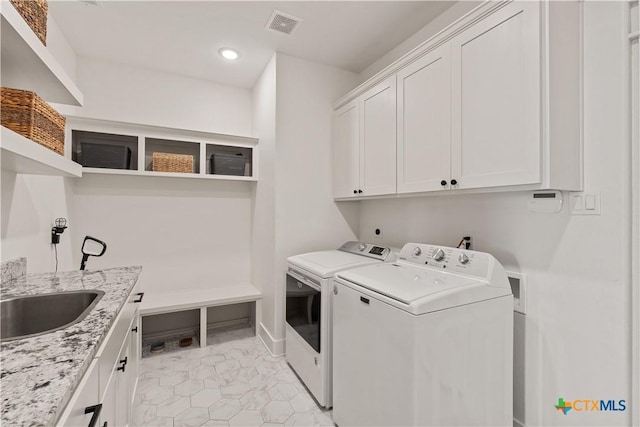 washroom with recessed lighting, visible vents, a sink, separate washer and dryer, and cabinet space