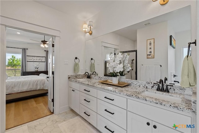 bathroom featuring a shower stall, double vanity, a sink, ensuite bath, and ceiling fan