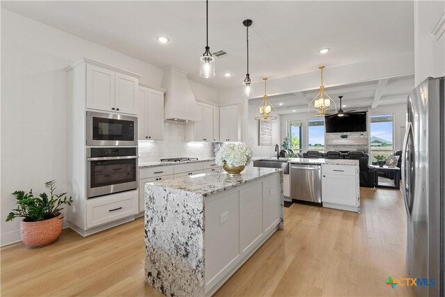 kitchen featuring decorative backsplash, stainless steel appliances, light wood-style flooring, custom range hood, and recessed lighting