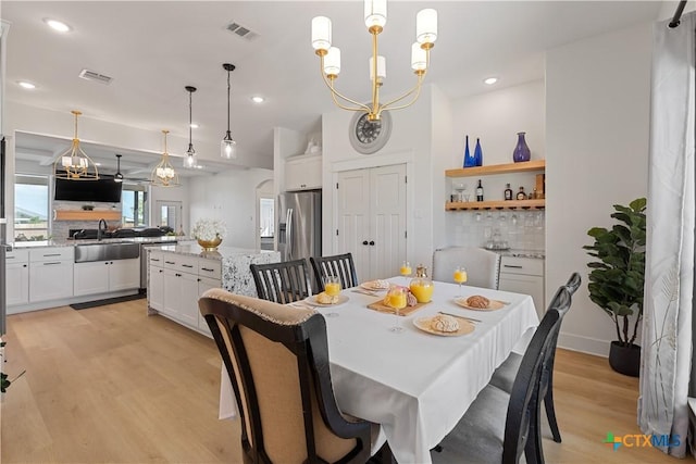 dining space featuring a chandelier, light wood-style floors, visible vents, and recessed lighting