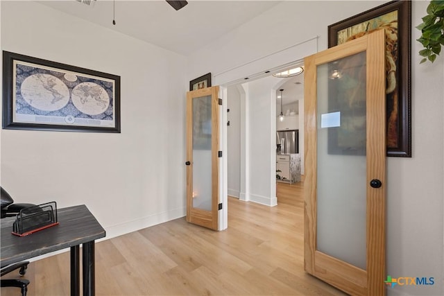 interior space with baseboards and light wood finished floors