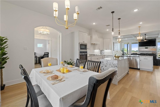 dining room with recessed lighting, light wood-type flooring, visible vents, and an inviting chandelier
