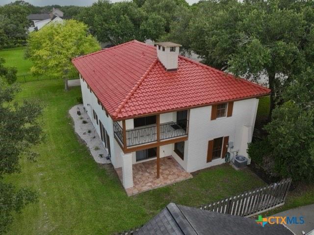 213 Tracy Ln, Victoria, TX 77904 - rear view of house with a tile roof, stucco siding, a chimney, and a patio area