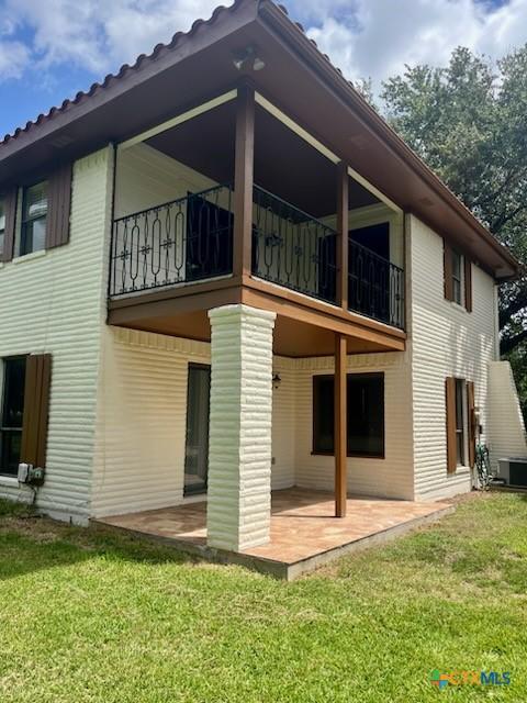213 Tracy Ln, Victoria, TX 77904 - back of house featuring a balcony, a patio, and a yard