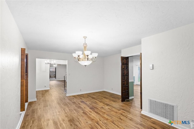 213 Tracy Ln, Victoria, TX 77904 - spare room featuring a chandelier and light wood-style floors