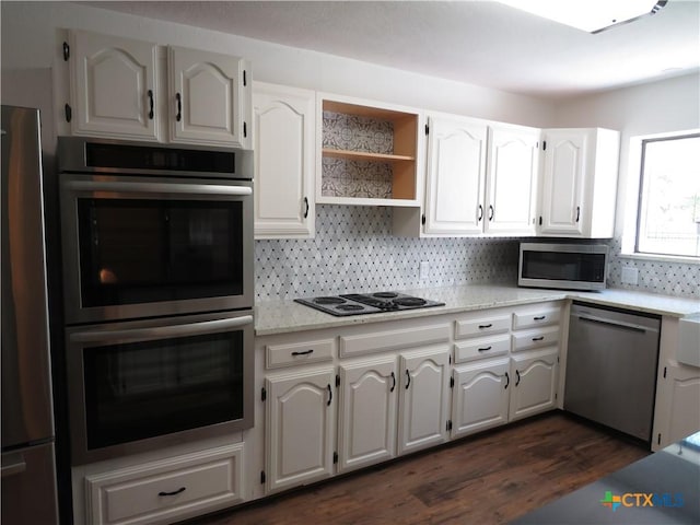 213 Tracy Ln, Victoria, TX 77904 - kitchen with appliances with stainless steel finishes, backsplash, dark wood-type flooring, and white cabinets