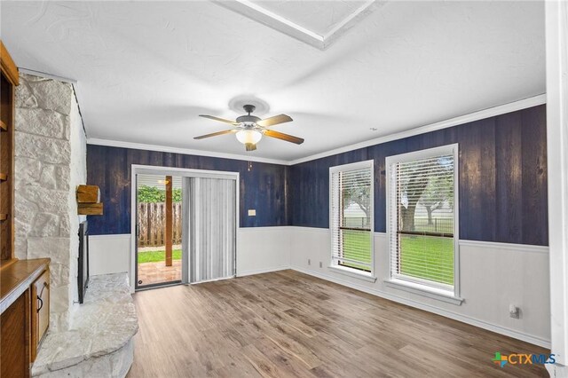 213 Tracy Ln, Victoria, TX 77904 - unfurnished living room with healthy amount of natural light, ornamental molding, wood finished floors, a ceiling fan, and wooden walls