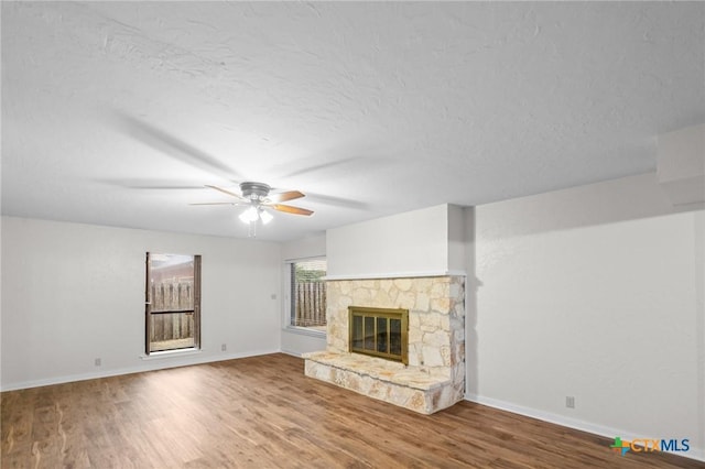 213 Tracy Ln, Victoria, TX 77904 - unfurnished living room with wood finished floors, a ceiling fan, a fireplace, and a textured ceiling
