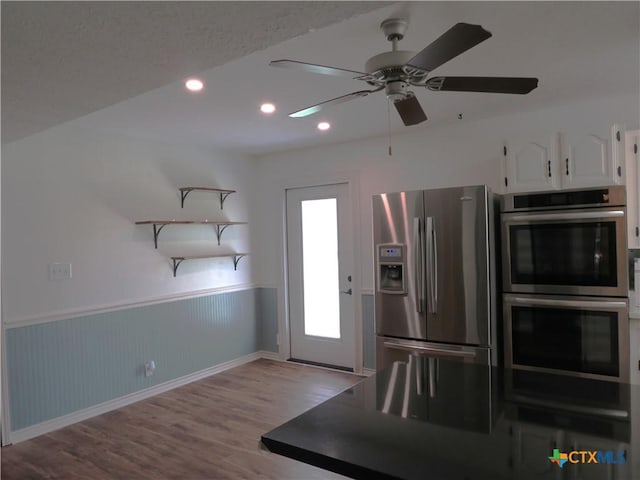 213 Tracy Ln, Victoria, TX 77904 - kitchen with stainless steel appliances, white cabinetry, wood finished floors, recessed lighting, and wainscoting