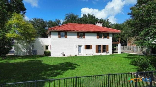 213 Tracy Ln, Victoria, TX 77904 - back of house featuring a chimney and a tiled roof