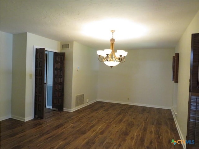 213 Tracy Ln, Victoria, TX 77904 - spare room featuring a chandelier and dark wood-style floors