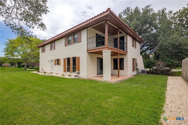 213 Tracy Ln, Victoria, TX 77904 - back of property with a balcony, a patio, and a lawn