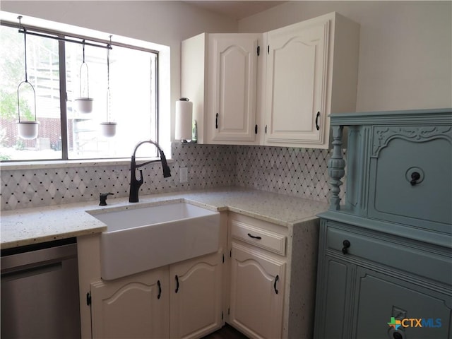213 Tracy Ln, Victoria, TX 77904 - kitchen with stainless steel dishwasher, tasteful backsplash, light stone counters, and white cabinets