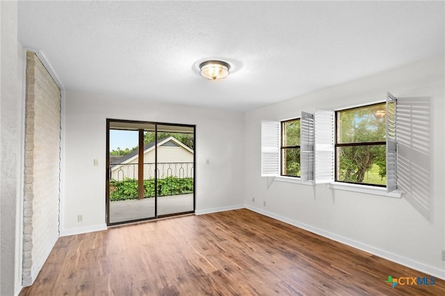 213 Tracy Ln, Victoria, TX 77904 - unfurnished room featuring healthy amount of natural light, wood finished floors, and a textured ceiling