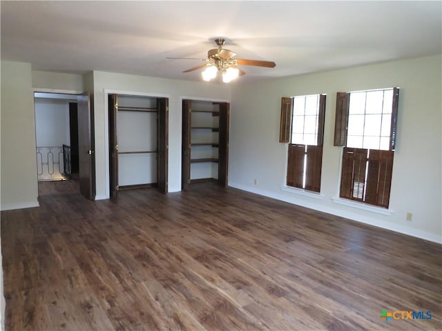 213 Tracy Ln, Victoria, TX 77904 - unfurnished bedroom with dark wood-type flooring, multiple closets, and a ceiling fan