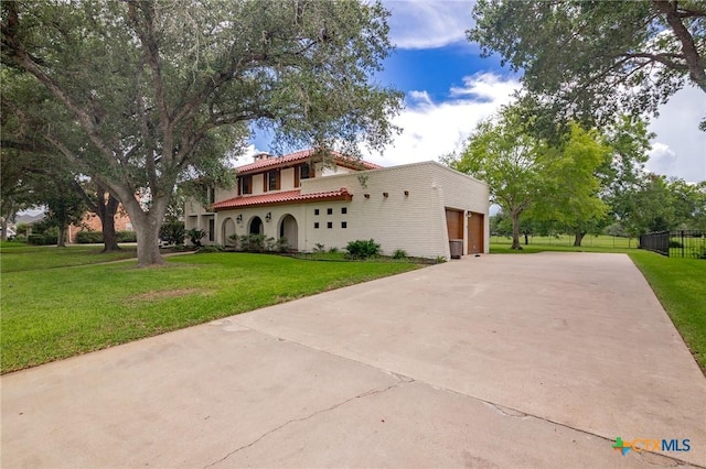 213 Tracy Ln, Victoria, TX 77904 - mediterranean / spanish home with a tile roof, driveway, an attached garage, a chimney, and stucco siding
