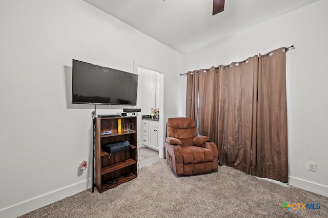 living area featuring light colored carpet and ceiling fan