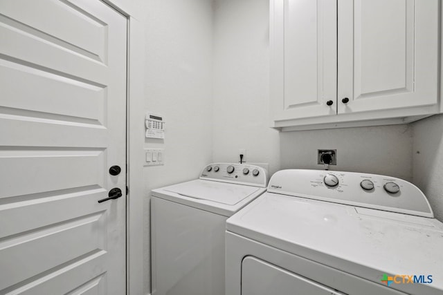 laundry area featuring washing machine and dryer and cabinets