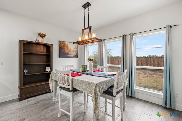 dining room with a chandelier, plenty of natural light, and light hardwood / wood-style floors