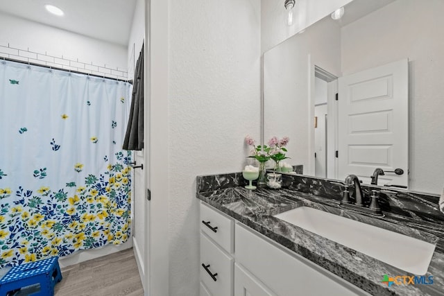 bathroom featuring a shower with shower curtain, vanity, and hardwood / wood-style flooring