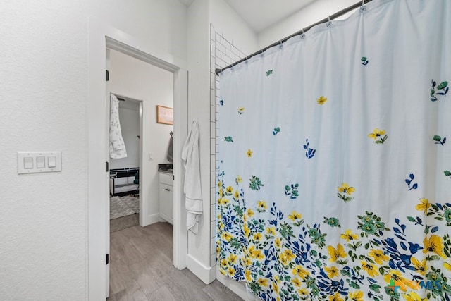 bathroom with a shower with shower curtain, hardwood / wood-style floors, and vanity