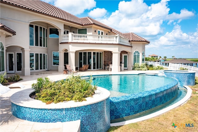 rear view of house featuring a patio and a balcony