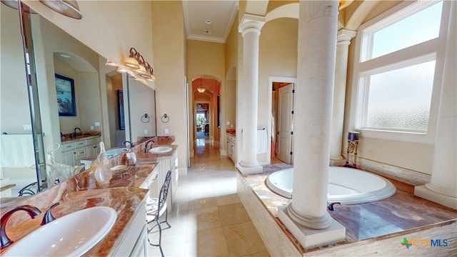 bathroom featuring a high ceiling, tile patterned flooring, vanity, crown molding, and tiled bath