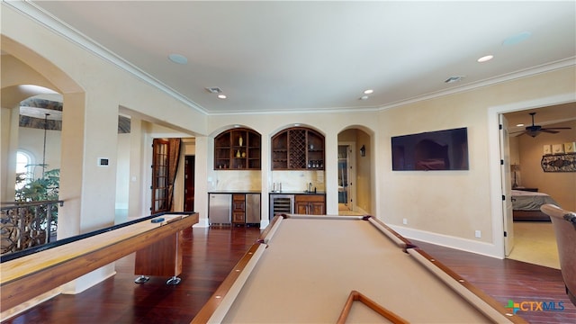 recreation room with bar, dark hardwood / wood-style floors, wine cooler, and crown molding