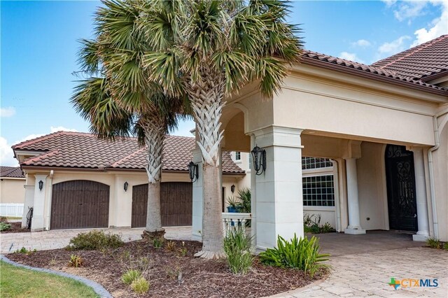 153 E Tuscany Way, Port Oconnor, TX 77979 - view of front of house with stucco siding, a tiled roof, and a garage
