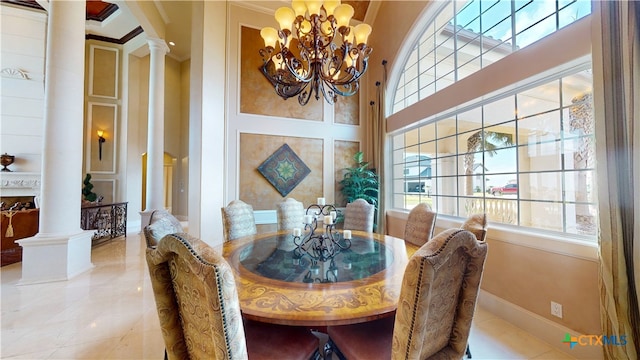 dining area with decorative columns, a chandelier, a towering ceiling, and crown molding