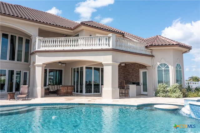 rear view of house featuring ceiling fan, a patio, and a balcony