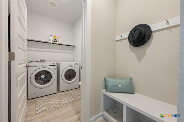 2917 Sage Ranch Dr, Leander, TX 78641 - laundry area with independent washer and dryer, light wood-style flooring, and a textured wall