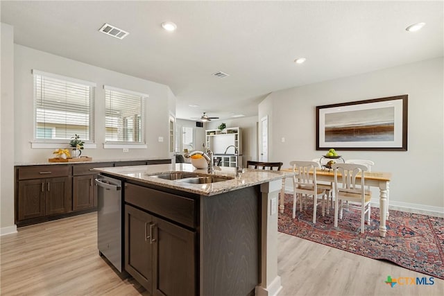 2917 Sage Ranch Dr, Leander, TX 78641 - kitchen with dishwasher, light wood-style flooring, a center island with sink, dark brown cabinetry, and recessed lighting