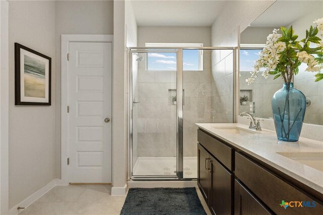 2917 Sage Ranch Dr, Leander, TX 78641 - bathroom featuring a shower stall, double vanity, and tile patterned flooring