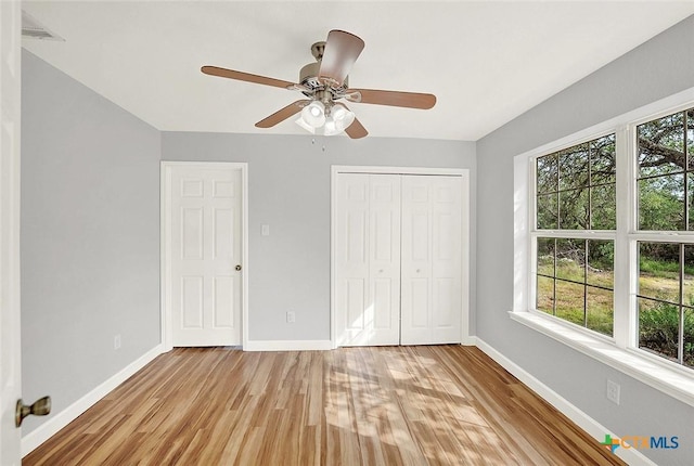 661 Abels Way, Canyon Lake, TX 78133 - unfurnished bedroom featuring light wood-style floors, baseboards, a closet, and a ceiling fan