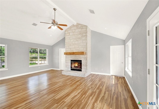661 Abels Way, Canyon Lake, TX 78133 - unfurnished living room with wood finished floors, a ceiling fan, healthy amount of natural light, beamed ceiling, and a fireplace