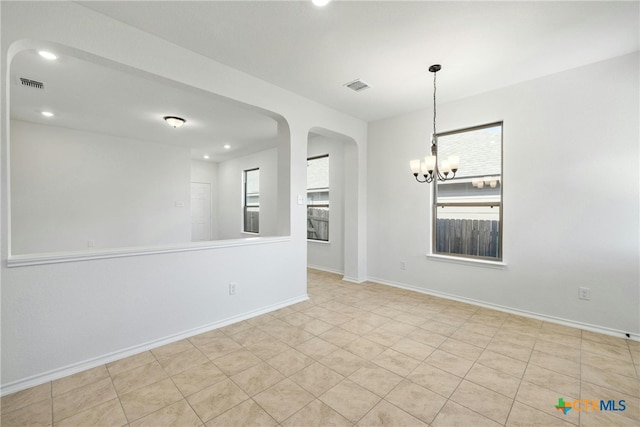 tiled empty room featuring a notable chandelier