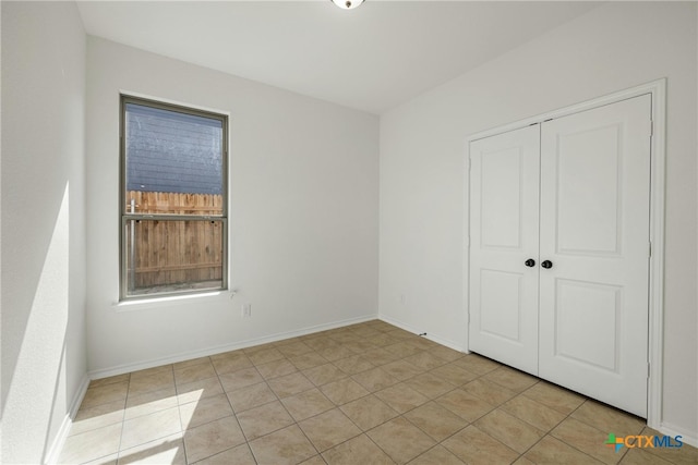 unfurnished bedroom with light tile patterned floors and a closet