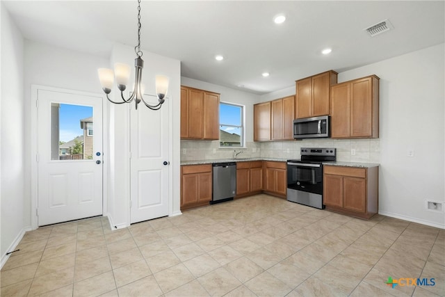 kitchen with backsplash, stainless steel appliances, sink, decorative light fixtures, and an inviting chandelier