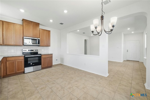 kitchen with light stone countertops, decorative backsplash, stainless steel appliances, decorative light fixtures, and an inviting chandelier