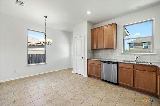 kitchen with sink, hanging light fixtures, stainless steel dishwasher, light stone countertops, and a chandelier