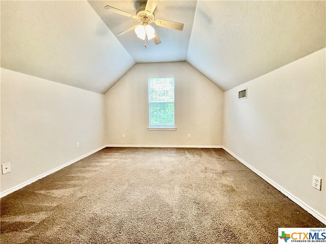 bonus room with lofted ceiling, a textured ceiling, carpet flooring, and ceiling fan